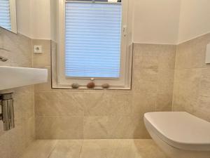 a bathroom with a sink and a toilet and a window at 1908 - Am Kurpark in Dahme +12 photos