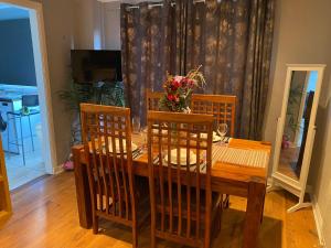 a wooden dining room table with chairs and a table and a table at Harbury Lodge in Scotstoun West Station