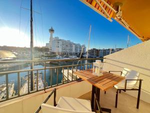 a balcony with a wooden table and chairs on a ship at Estudio Frente al Canal con Terraza in Empuriabrava