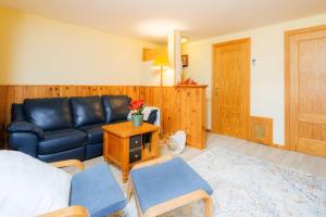 a living room with a black leather couch and chairs at Villa Garmet Formigal in Formigal