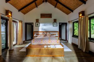 a bedroom with a bed in a room with windows at Bagh Villas I Kanha in Kānha +38 photos