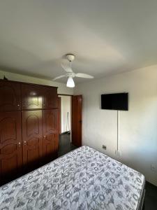 a bedroom with a bed and a ceiling fan at Residencial Lagomar, sol e mar para relaxar! in Saquarema