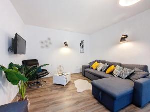 a living room with a couch and a chair at Au N5 - Confort - Emplacement central - Proche Strasbourg et Europapark - Parking in Benfeld