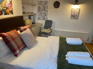 a bedroom with a bed with towels on it at London Luxe Rooms in Surbiton +14 photos