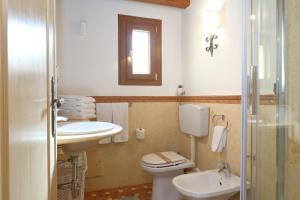 a bathroom with a toilet and a sink and a mirror at Duomo Apartments Cefalù in Cefalù +66 photos