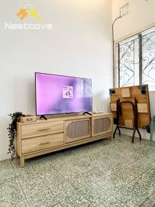 a flat screen tv sitting on top of a wooden entertainment center at D Simple Haus By Nestcove in Melaka