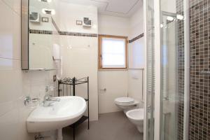a white bathroom with a sink and a toilet at Appartamenti Lea Pontiglia in Livigno