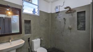 een badkamer met een toilet, een wastafel en een douche bij Surf edge villa in Mawella