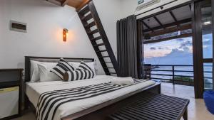 een slaapkamer met een bed met uitzicht op de oceaan bij Surf edge villa in Mawella