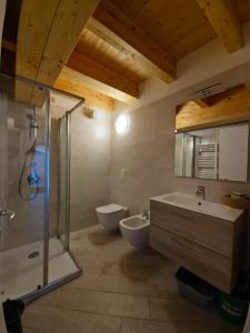 a bathroom with two sinks and a shower and a toilet at casa antico borgo - appartamento 1 in Assenza di Brenzone
