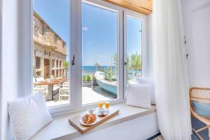 Una habitación con una ventana con vista al mar. en Skiff - Transformed studio on the water's edge, en La Canea