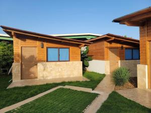 a house with a green lawn in front of it at Serene Punta Cana Cabin Retreat - Private Pool BBQ in Punta Cana
