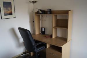 a desk with a chair in a room with a lamp at Vail next to coffee mecca in Canberra