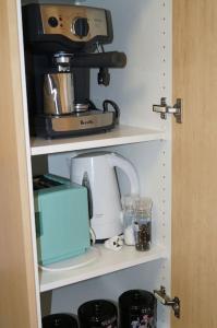 a coffee maker on a shelf in a kitchen at Vail next to coffee mecca in Canberra