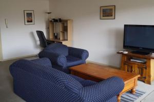 a living room with two chairs and a television at Vail next to coffee mecca in Canberra