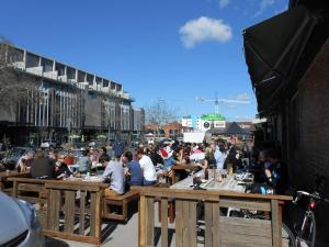 a crowd of people sitting at tables in a street at Vail next to coffee mecca in Canberra