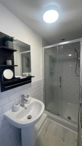 a white bathroom with a sink and a shower at Papa guest in Poole +7 photos