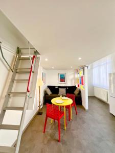 a living room with a table and a staircase at L'Atypique, Confort, Centre-ville in Royan