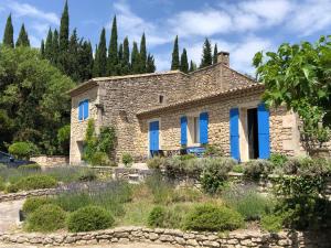 kamienny dom z niebieskimi oknami i drzewami w obiekcie very pleasant provençal mas, typical to the region, with heated pool in saint remy de provence - 9 people w mieście Saint-Rémy-de-Provence