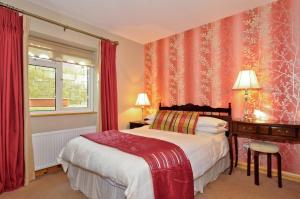 a bedroom with a bed and a window with red curtains at Rowanville Lodge in Grange