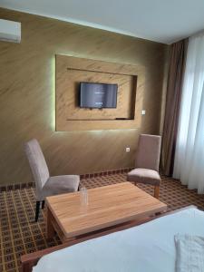 una camera con tavolo, due sedie e una TV di Hotel Victoria a Sarajevo