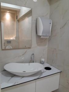 un bagno bianco con lavandino e specchio di Hotel Victoria a Sarajevo