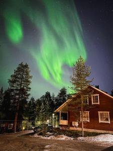 una casa con la aurora boreal en el cielo en Villa Sinirinta, Ounasvaara, en Rovaniemi