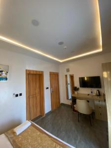 伊巴丹Lighthouse Inn and suites的有一张床、一张书桌和一台电视的房间