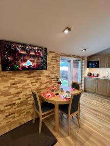 a dining room with a table and a television on a wall at Apartament Vanessa 2 u podnóża gór, nad jeziorem Czorsztyńskim in Harklowa