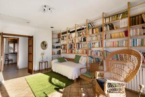 a room with a bed and bookshelves at Les Corts De Biosca in Castelltallat