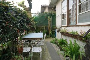 バギオにあるLE-ONIES's Blue Ginger Room at City Centerの庭園内のパティオ(テーブル、椅子付)