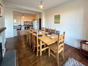 a dining room with a wooden table and chairs at Glannant - 5 Bed & 4 Bathroom - Fairbourne, Barmouth, Mawddach Estuary in Arthog