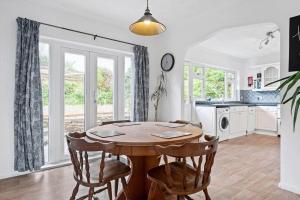 une salle à manger avec une table et des chaises en bois dans l'établissement Peaceful Home in Looe with Stunning Views, à Looe