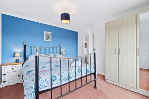 une chambre avec un lit avec un mur bleu dans l'établissement Peaceful Home in Looe with Stunning Views, à Looe
