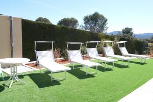 a row of white chairs and tables on grass at very beautiful villa with private pool in the luberon enjoying a magnificent view of the durance valley, located in puget – 10 people. in Puget +37 photos