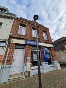 a street light in front of a brick building at Sunny - Hypercentre - Fibre in Sin-le-Noble