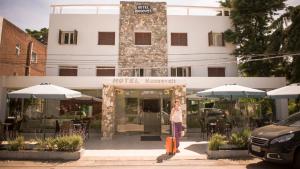 a woman standing in front of a hotel with a suitcase at Hotel Roosevelt in Punta del Este
