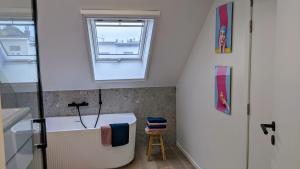 a small bathroom with a tub and a window at Guesthouse Josephine - Antwerpen in Antwerp +21 photos