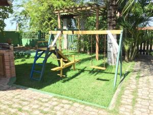 a playground with a blue ladder and a swing at Pousada Recanto Verde e Mar in Araruama