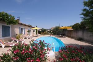 basen z leżakami i parasolami na dziedzińcu w obiekcie pretty holiday rental with swimming pool in isle-sur-la-sorgue, in the département of vaucluse, in provence 4 people w mieście LʼIsle-sur-la-Sorgue