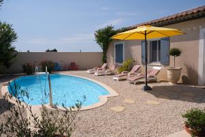 basen z krzesłami i parasolem w obiekcie pretty holiday rental with swimming pool in isle-sur-la-sorgue, in the département of vaucluse, in provence 4 people w mieście LʼIsle-sur-la-Sorgue