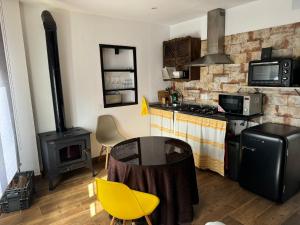 a kitchen with a stove and a table and yellow chairs at Apartamento rural Julio in Trevélez