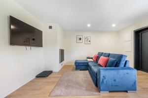 a living room with a blue couch and a tv at Chalés Avelino Carolino ll com Roteiro incluído in Chaves