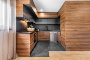 a kitchen with wooden walls and a sink and a dishwasher at Chalés Avelino Carolino ll com Roteiro incluído in Chaves