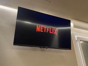 Un televisor de pantalla plana colgado en una pared en Queen rooom ModeRna - Relax e privacy a 2 passi dal Duomo, en Módena 11 fotos más