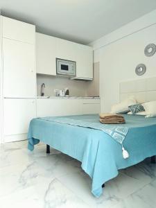 a bedroom with a blue bed in a white room at Sunny Oceanview studio apartment Ponderosa in Costa Adeje in Playa de las Americas