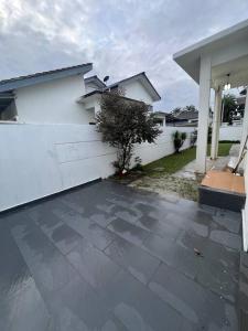 a driveway of a house with a white fence at Rumah Cemara by Impian Homestay in Sepang