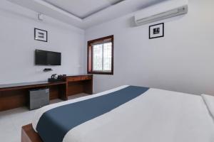 维沙卡帕特南Super Hotel O Stay Inn Maharani Peta的一间带大床和电视的卧室