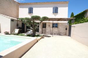 a villa with a swimming pool and a house at charming house with private pool in the heart of the village of aureille in the alpilles, 6 people. in Aureille