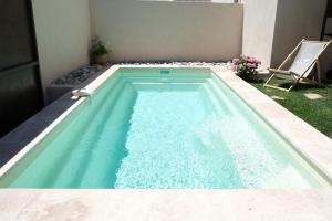 a swimming pool with blue water in a backyard at charming house with private pool in the heart of the village of aureille in the alpilles, 6 people. in Aureille